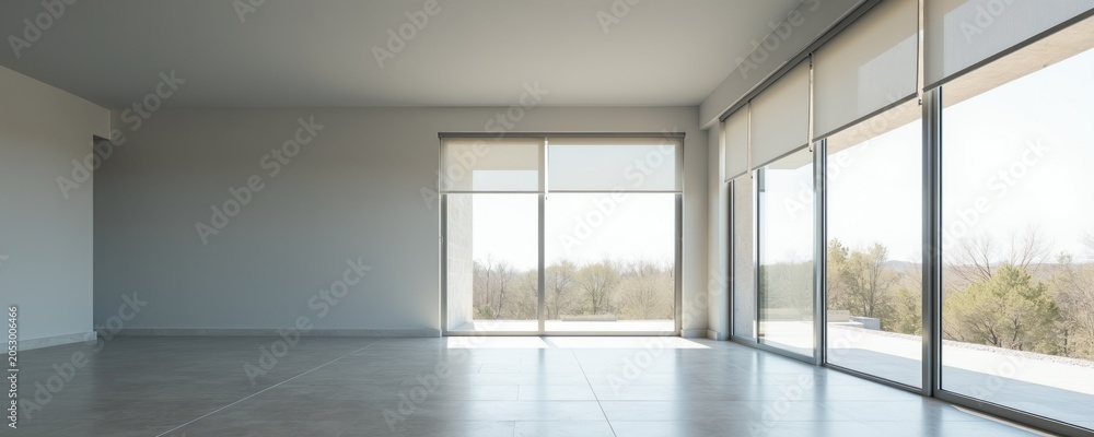 Fototapeta premium Modern empty room with large windows and natural light. Minimalist interior with grey floor and white walls offers clear view of trees and sky. Space ready for furniture.