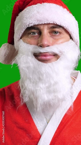 Santa Claus in red costume on green chroma key background. Christmas and New Year celebration concept. Vertical footage
