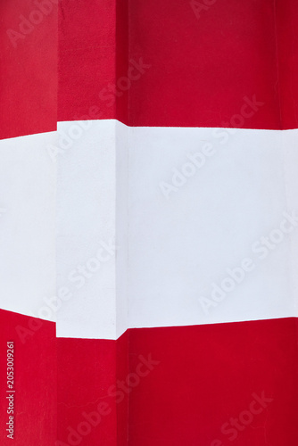détail de la façade d'un phare en béton rouge et blanc