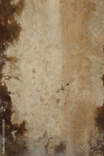 détail de texture sur un mur décrépi ocre et marron de la façade d'une vieille maison en béton 