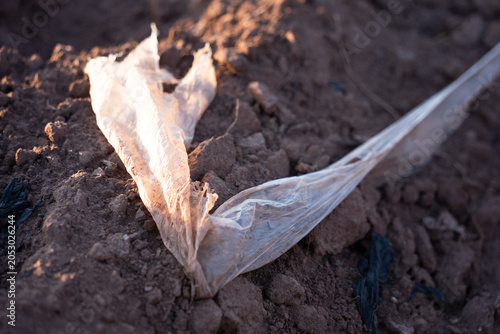 Tablou pe pânză Close-up of discarded plastic bag on soil highlighting environmental pollution