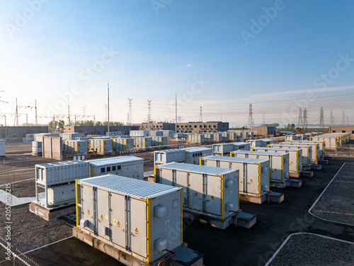 rows of energy storage battery containers at outdoor power station under blue sky