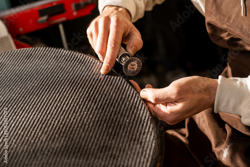 Close-up of Luthier Hands Working on Carbon Fiber Cello Part With Electric Tool in Workshop