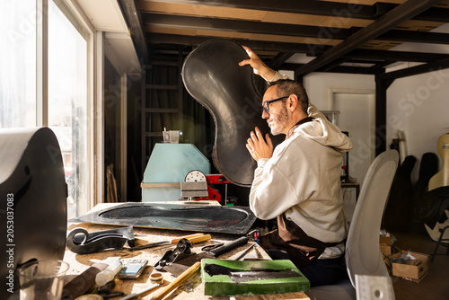 Luthier Checks the Sounds of a Carbon Fiber Cello Part in Workshop