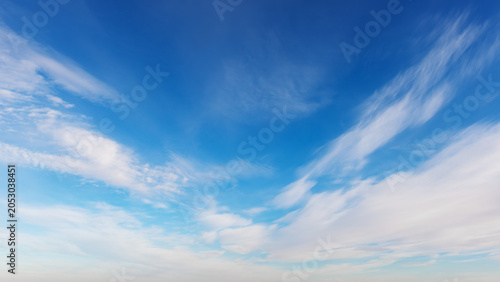 Blue sky background with soft white clouds. Wide horizontal summer day sky background banner representing freedom, inspiration and clarity.