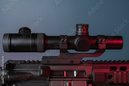 Foto Tactical Rifle Scope Mounted on Firearm Upper Receiver Under Cinematic Neon Ligh