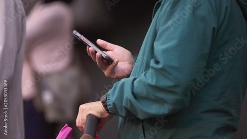 Slow motion unrecognizable metro passengers use smartphones while standing inside the train, showing commuting, public transportation, digital communication and modern city life