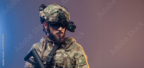 Fotografie Male soldier in tactical gear with night vision goggles and rifle, showcasing mi