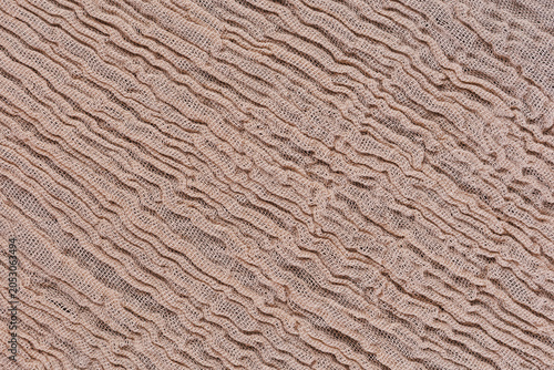 Photos Diagonal beige gauze muslin fabric texture with soft crinkled cotton folds and w