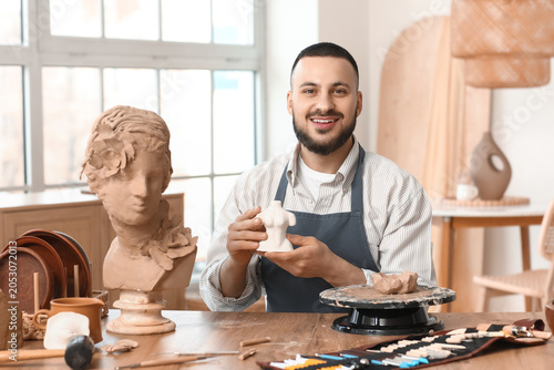 Young male sculptor with pl...