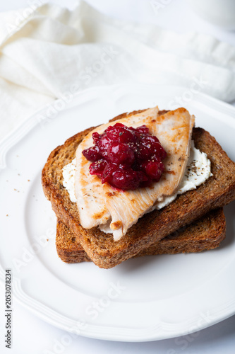 Open Sandwich with leftover turkey slices with cranberry sauce on top. Perfect holiday breakfast or lunch