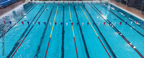 swimming in indoor pool, lane lines, flags, concept of tourism, sports, fitness, copyspace