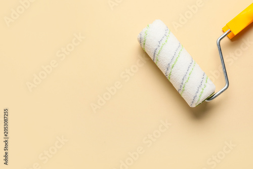 Paint roller on beige backg...