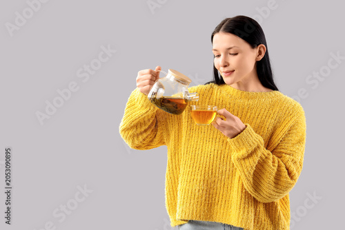 Young woman pouring green t...