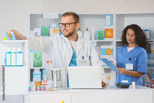 Smiling male pharmacist rea...