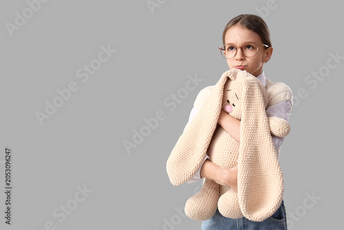 Sad girl hugging toy bunny ...