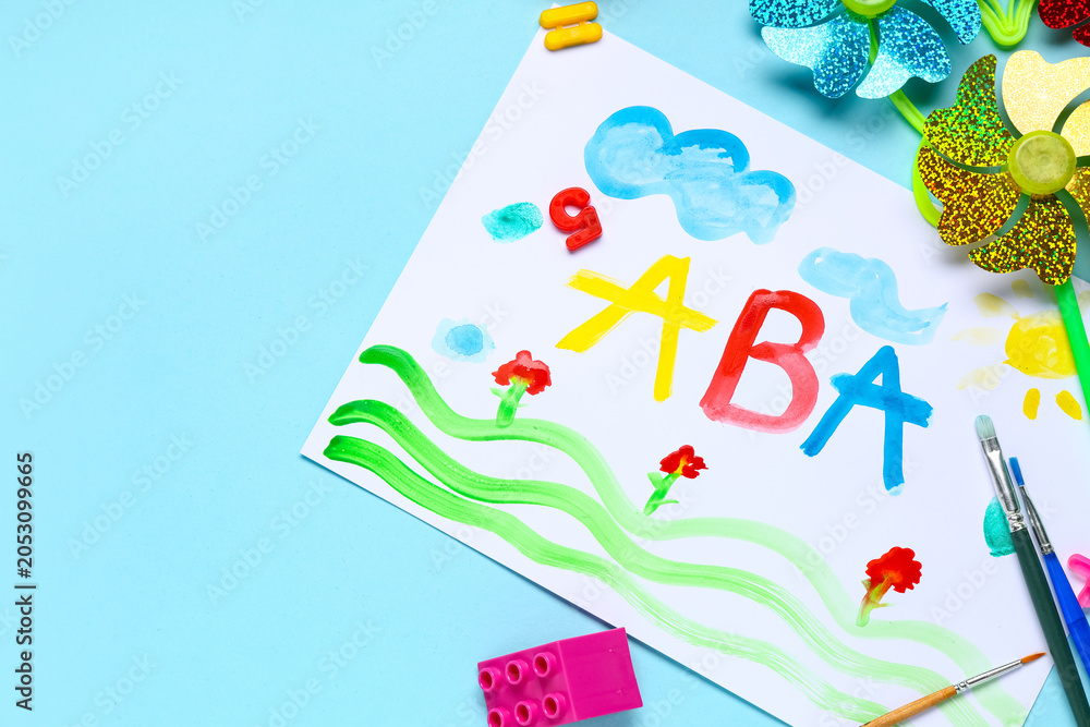 Naklejka premium Children's creative learning activity with colorful ABC painting, art supplies, and educational toys on blue background