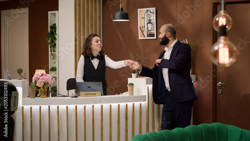 Принти на полотні Hotel staff hands out access card for entrepreneur, ensuring comfortable and has