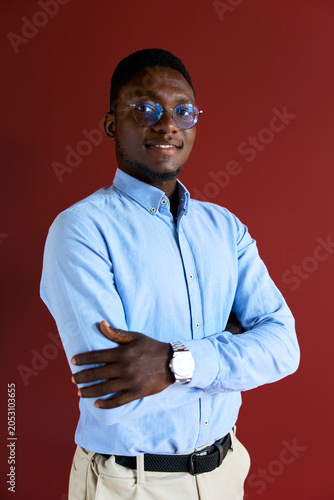 Bild auf Leinwand Confident black businessman standing with crossed arms, smiling at camera, weari