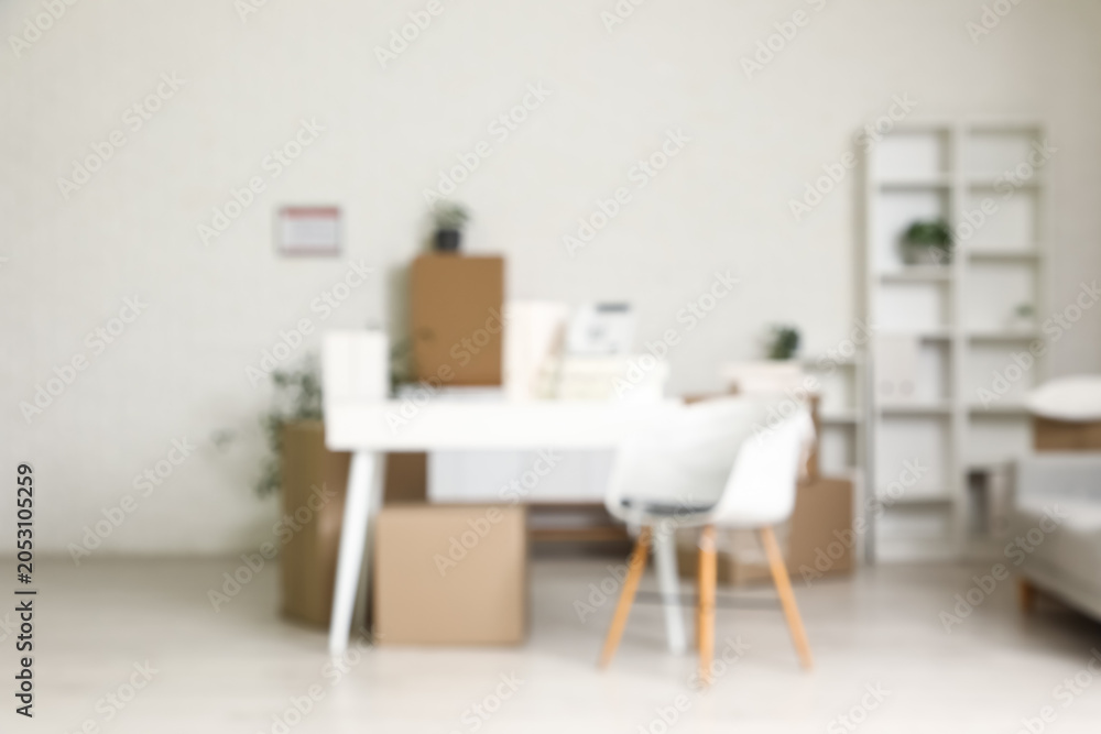 Fototapeta premium Blurred background of modern office or home interior with desk, chair, and moving boxes, new beginnings