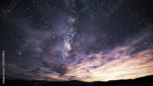Time Lapse of Milky Way Galaxy and Stars Moving Across a Night Sky Over Silhouetted Mountains, Clouds Drifting, Cosmic Panorama, 4K