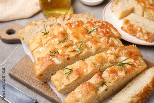 Bild auf Leinwand Board with pieces of tasty traditional Genovese focaccia on grey grunge backgrou