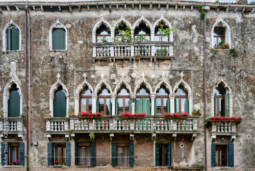 Fotografía Ornate historic facade of a Venetian palace featuring gothic arch windows, stone