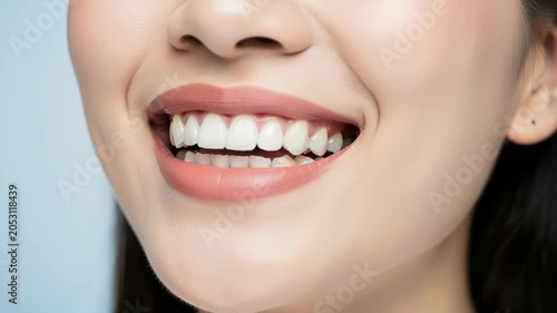 Radiant Smile: A close-up shot captures a woman's beautiful, healthy white teeth as she smiles, her lips adorned with soft pink lipstick.
