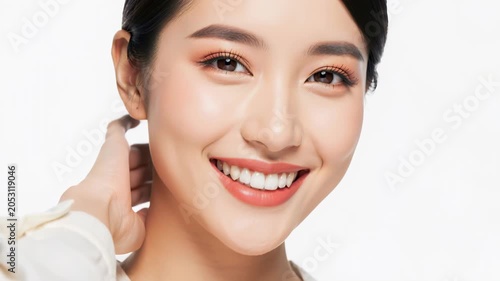 Radiant Smile: A beautiful young Asian woman with flawless skin and subtle makeup flashes a warm, genuine smile, her eyes sparkling with inner joy.