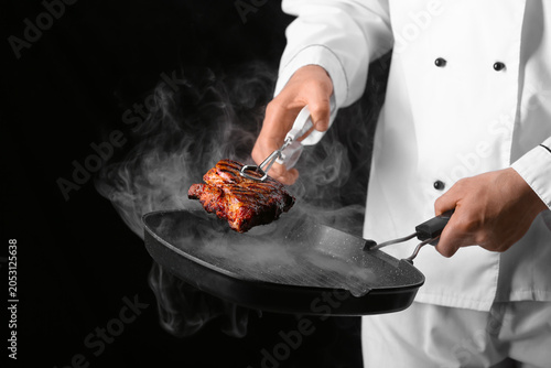 Male chef frying meat on gr...