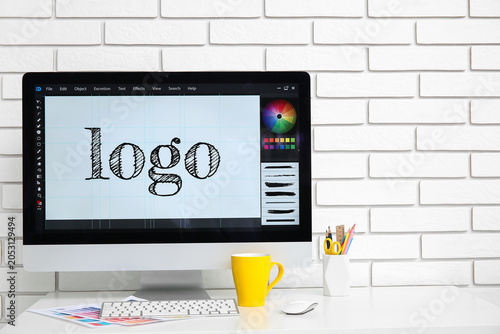Workplace of graphic designer with modern computer, color charts and tea on w...