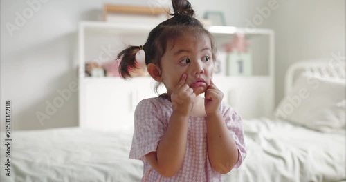 Cute Asian Toddler Girl with Pigtails Making Funny Face  with Eye Contact, Happy Daughter Having Quality Time with Mother in Cozy Domestic BedRoom