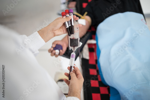 Selective focus hand of doctor inject blood from donor arm into bag while donating blood at blood bank unit in hospital.Donation for emergency surgery at donation center.Save life and medical concept.