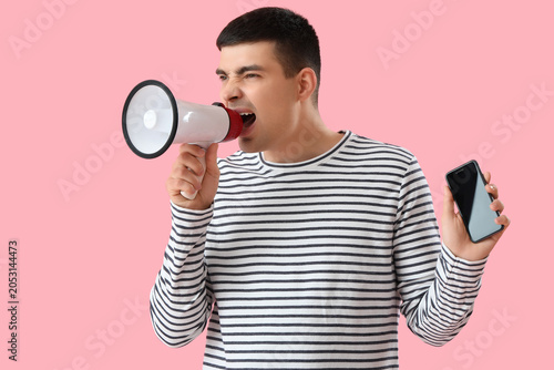 Angry young man with smartp...