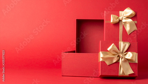 Gift Box and Ribbon: A festive red gift box, tied with a golden ribbon, sits beside an open box, evoking anticipation and the joy of giving.