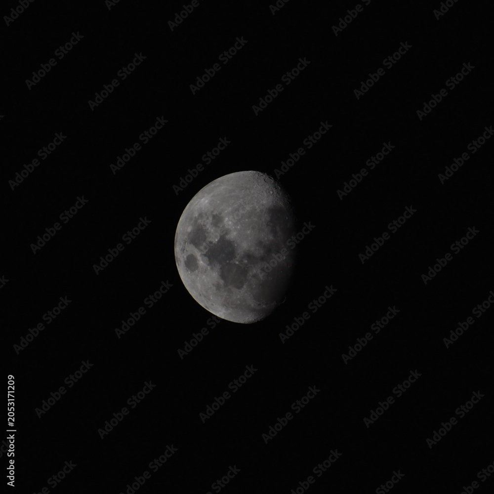 Obraz premium Close up of a three quarter moon in front of a black sky