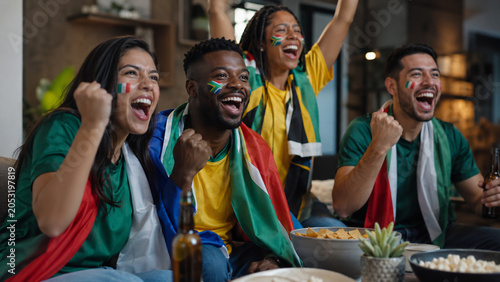 Mexican and South African fans celebrating football match indoors