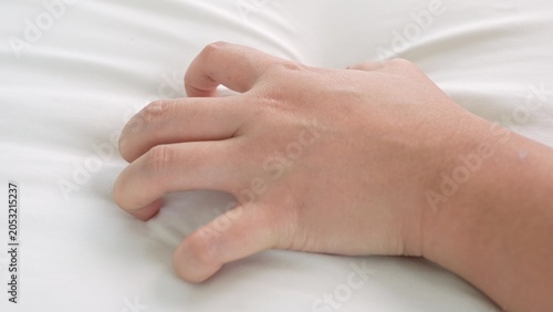 Fotografía The tense hand pressing into the white fabric reflects raw emotion and heightened sensation