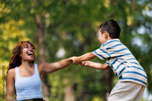 Happy mother and son enjoying playful moments together in the park