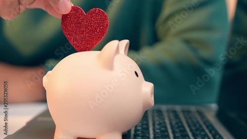 Φωτογραφία A salaried employee placing a red heart on a piggy bank, symbolizing saving with care, and also reflects emotional value in money, financial security, work-life love, and meaningful investment
