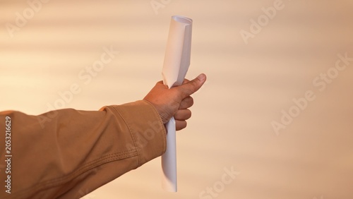 Fotografia An office worker in a brown jacket tightly grasps and crumples a work document, symbolizing frustration with bureaucracy, discarding unproductive tasks, and seeking workplace change