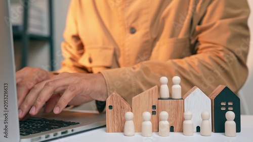 Cuadro en lienzo A real estate entrepreneur places wooden figurines near house models, symbolizing strategic efforts to identify target homebuyers, highlighting the importance of community in residential development