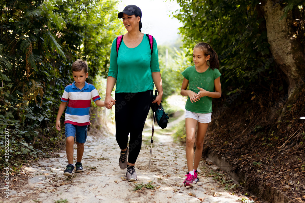 Naklejka premium Family Enjoying a Scenic Walk on a Nature Trail During a Sunny Day