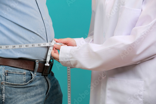Concerned doctor measures obese patient waist using measuring tape during hopeful medical checkup supporting healthy weight loss journey