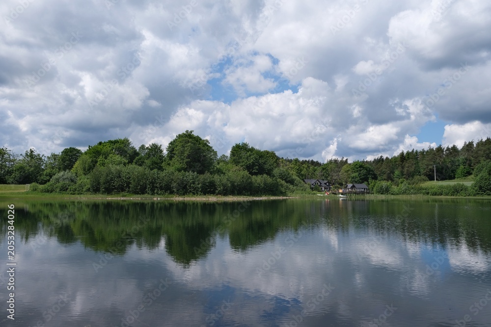 Obraz premium Amazing scenery of kashubian landscape with Grabowko lake and clouds on blue sky in summer day. Kashubia, Pomerania, Poland
