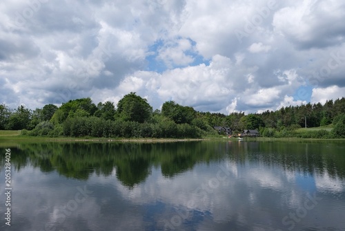 Amazing scenery of kashubian landscape with Grabowko lake and clouds on blue sky in summer day. Kashubia, Pomerania, Poland