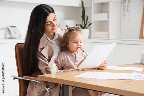 Working mother holding baby...