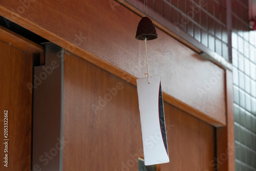 Bild auf Leinwand Simple wind chime hanging on a wooden door