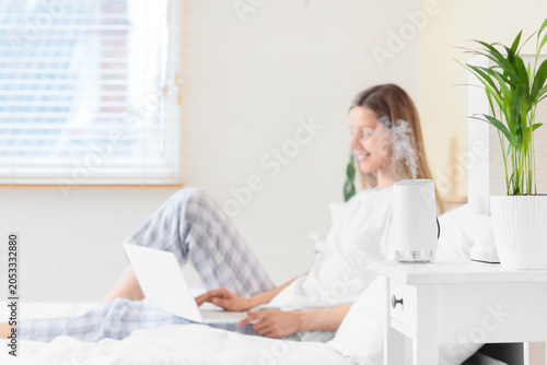 Woman relaxing in bed with ...