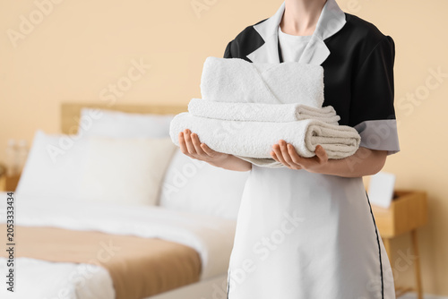 Bild auf Leinwand Hotel housekeeper carrying freshly folded white towels for room service and gues